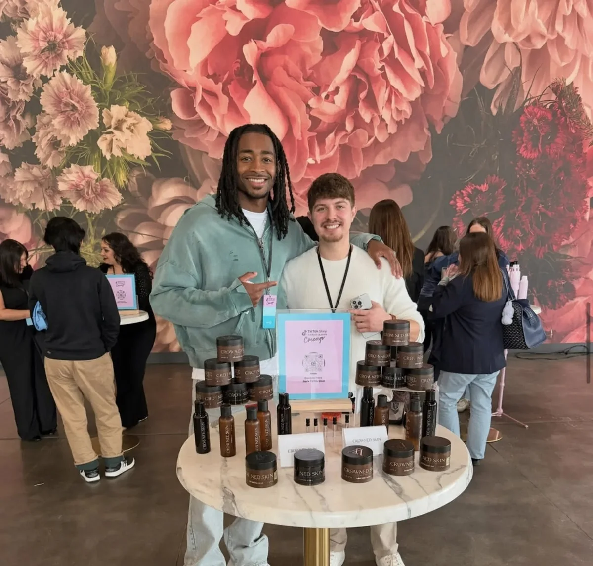 Cole Dockery with another attendee behind a Crowned Skin product display at a TikTok Shop Chicago event.
