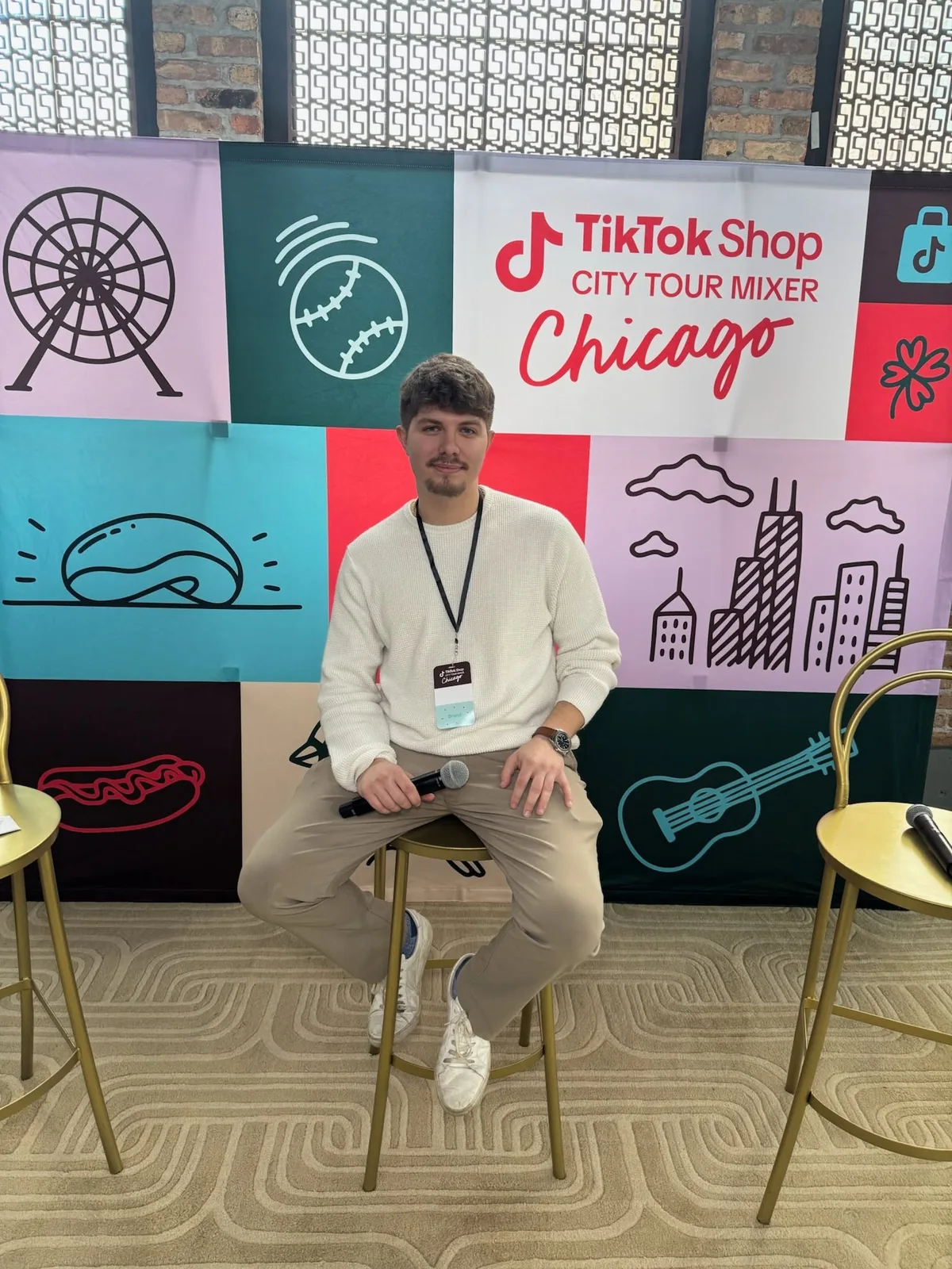 Cole Dockery holding a microphone in front of the TikTok Shop City Tour Mixer Chicago backdrop.